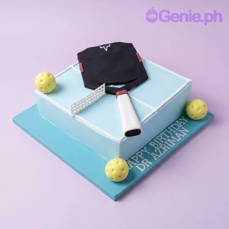 Light blue square fondant cake designed as a pickleball court with a black paddle and yellow balls Light blue square fondant cake designed as a pickleball court with a black paddle and yellow balls