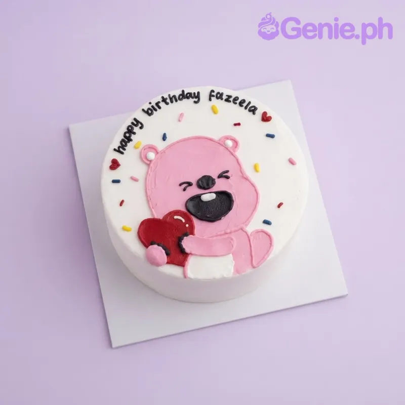 White bento cake with smooth soft icing, a pink bear holding a red heart piped doodle, and colorful sprinkles White bento cake with smooth soft icing, a pink bear holding a red heart piped doodle, and colorful sprinkles
