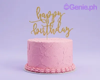 A pink 1-tier minimalist birthday cake, featuring a gold glitter 'Happy Birthday' cardstock topper and pink icing ruffles. A pink 1-tier minimalist birthday cake, featuring a gold glitter 'Happy Birthday' cardstock topper and pink icing ruffles.