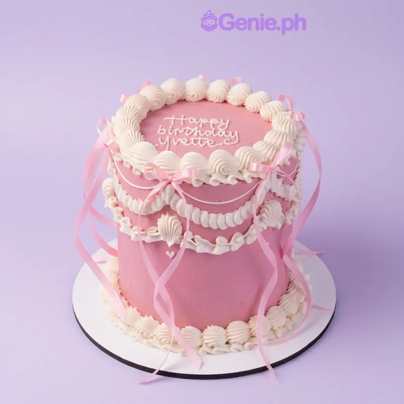 Pink 1-tier birthday cake with white piped icing swags and pink satin ribbon bows Pink 1-tier birthday cake with white piped icing swags and pink satin ribbon bows