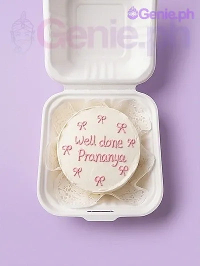 A white and pink Bento cake themed around pink bows, featuring piped pink icing bows and a 'Well done Prananya' message. A white and pink Bento cake themed around pink bows, featuring piped pink icing bows and a 'Well done Prananya' message.