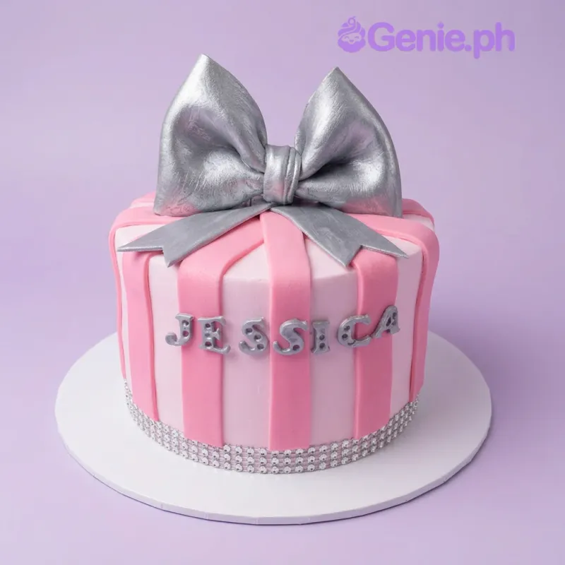 A pink and light pink 1 Tier Fondant cake themed around Pink Bow, featuring a large silver bow, silver name letters, and a rhinestone border. A pink and light pink 1 Tier Fondant cake themed around Pink Bow, featuring a large silver bow, silver name letters, and a rhinestone border.