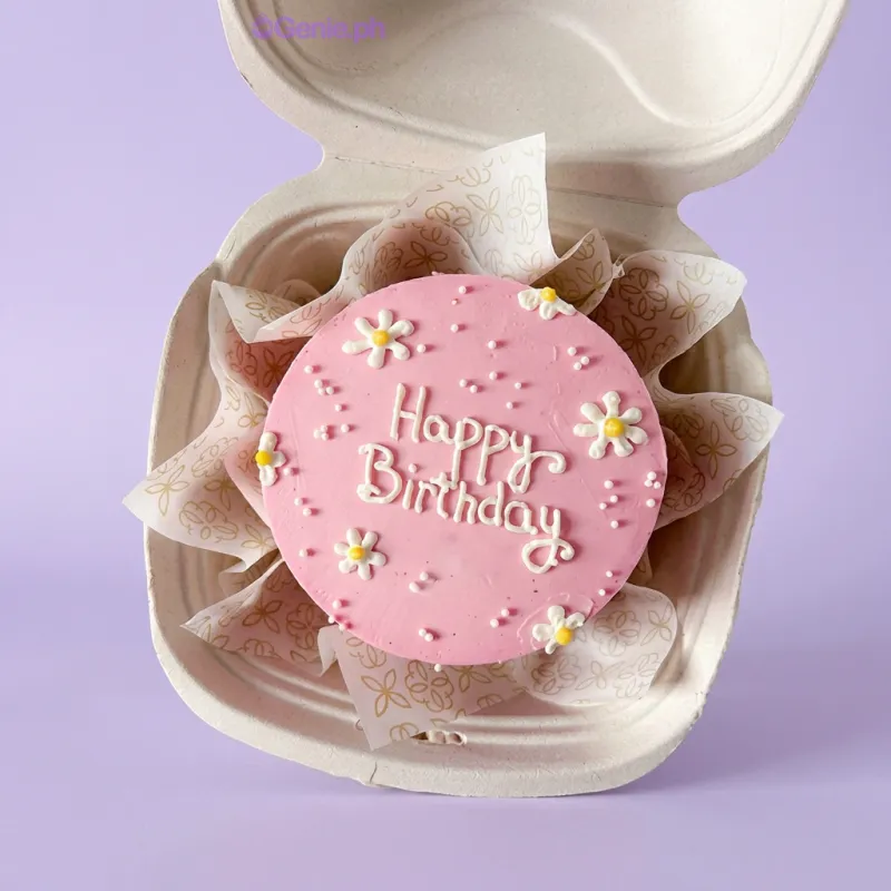 Pink bento cake with smooth soft icing, piped white daisy decorations, and white piped Happy Birthday text Pink bento cake with smooth soft icing, piped white daisy decorations, and white piped Happy Birthday text