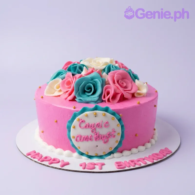 A pink, teal, white, and gold 1 Tier round cake themed around Pink Floral, featuring teal, pink, and white fondant roses and gold dragees with personalized text. A pink, teal, white, and gold 1 Tier round cake themed around Pink Floral, featuring teal, pink, and white fondant roses and gold dragees with personalized text.