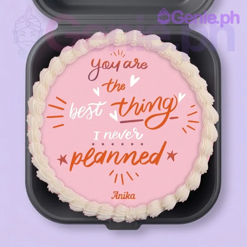 A pink 1-tier minimalist cake, featuring a quote graphic, 'Anika' text, and a white piped border. A pink 1-tier minimalist cake, featuring a quote graphic, 'Anika' text, and a white piped border.