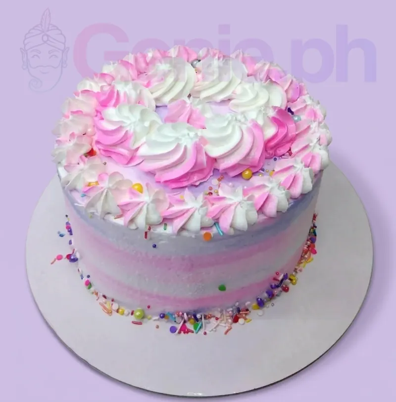 A pink, white, and lavender 1-tier cake themed around Pink Swirl, featuring two-tone piped rosettes and multi-colored sprinkles. A pink, white, and lavender 1-tier cake themed around Pink Swirl, featuring two-tone piped rosettes and multi-colored sprinkles.
