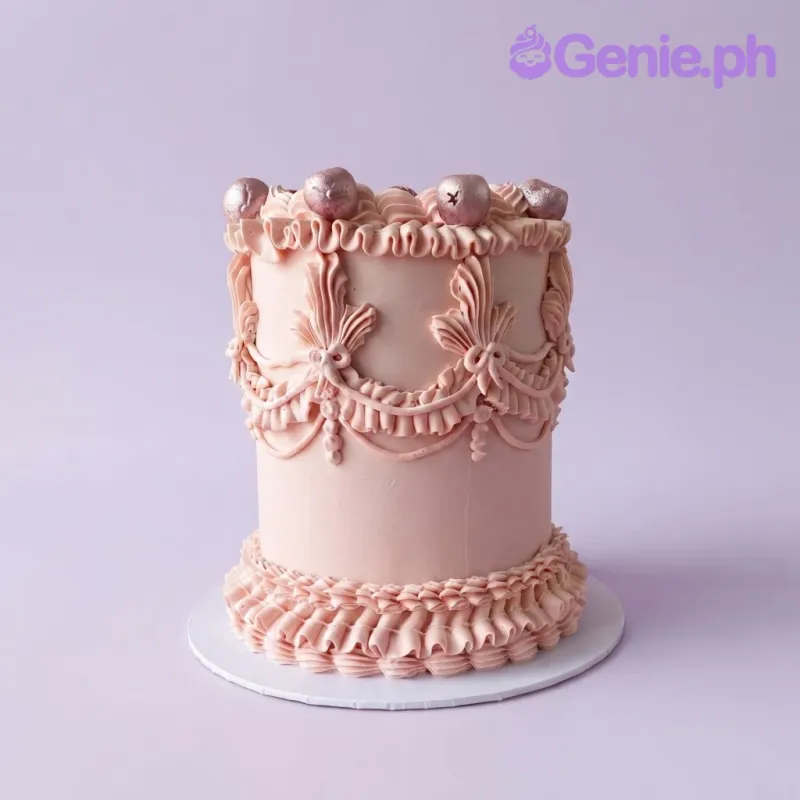 Pink vintage 1-tier cake with soft icing, piped icing swags, and rose gold decorative spheres