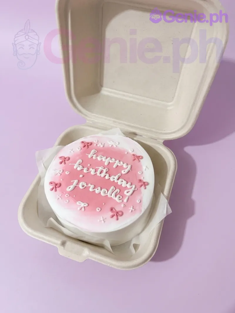 A pink and white Bento cake themed around Pink Watercolor, featuring piped bows and a 'Happy Birthday Jorselle!' message. A pink and white Bento cake themed around Pink Watercolor, featuring piped bows and a 'Happy Birthday Jorselle!' message.