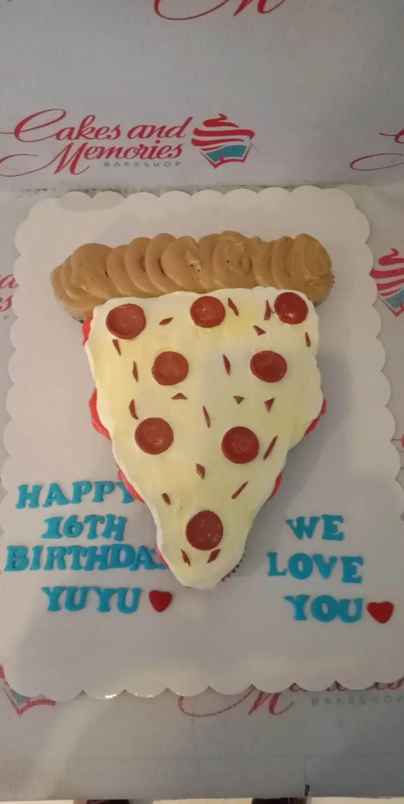 A white, red, tan pull-apart cupcake cake, pizza-themed, with pepperoni, crust icing, and blue messages. A white, red, tan pull-apart cupcake cake, pizza-themed, with pepperoni, crust icing, and blue messages.