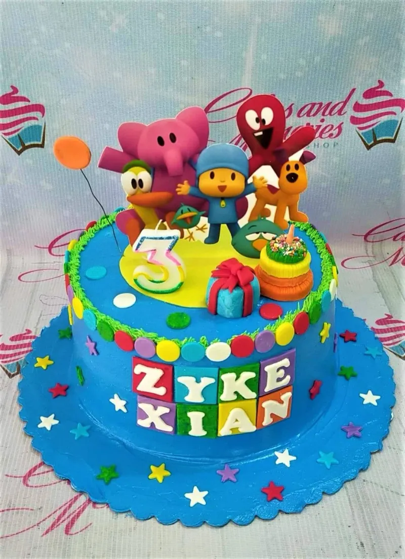 A blue 1-tier Pocoyo cake featuring Pocoyo, Elly, Pato, Fred, and Loula fondant figures, a number 3 candle, and colorful stars. A blue 1-tier Pocoyo cake featuring Pocoyo, Elly, Pato, Fred, and Loula fondant figures, a number 3 candle, and colorful stars.