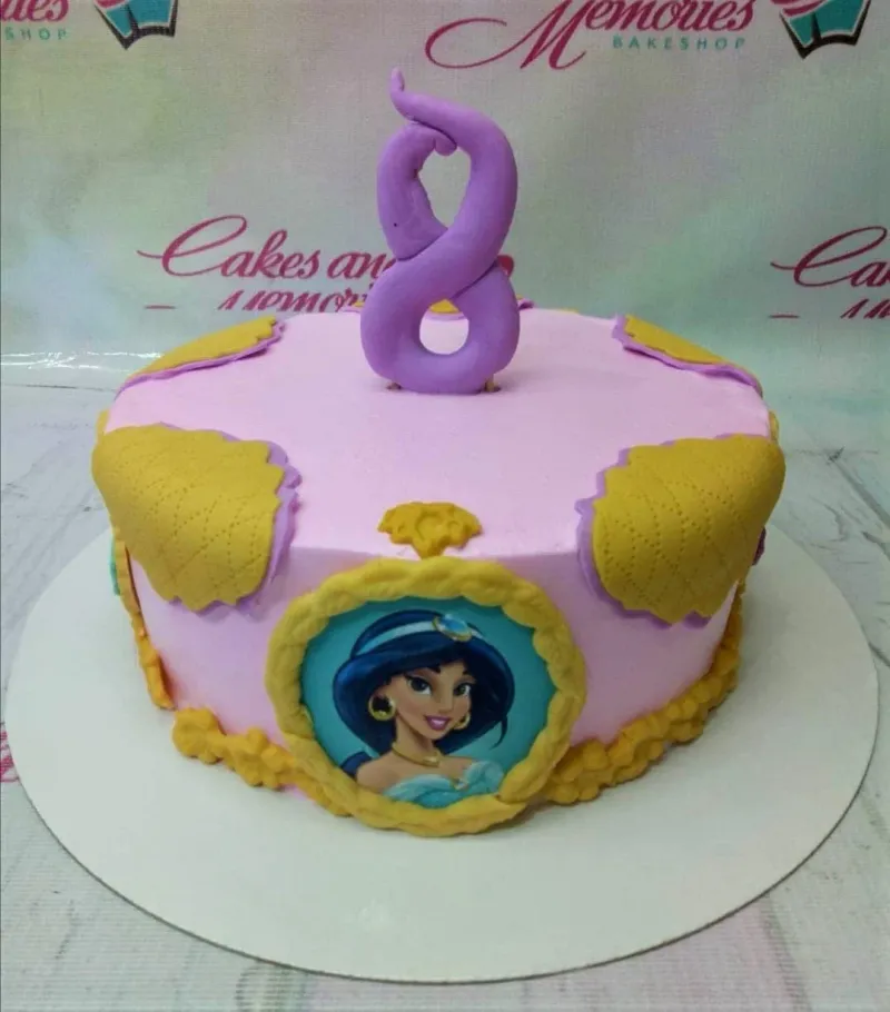 A pink and gold Princess Jasmine 1 Tier cake, with a character portrait, purple number 8, and quilted patterns. A pink and gold Princess Jasmine 1 Tier cake, with a character portrait, purple number 8, and quilted patterns.