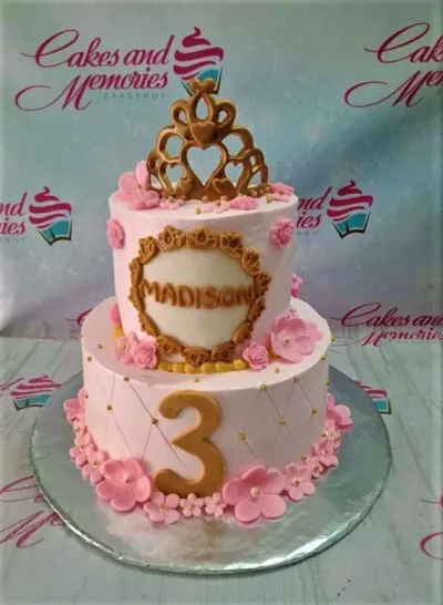 Pink 2-tier princess cake with a gold crown topper, pink fondant flowers, and a gold number 3. Pink 2-tier princess cake with a gold crown topper, pink fondant flowers, and a gold number 3.