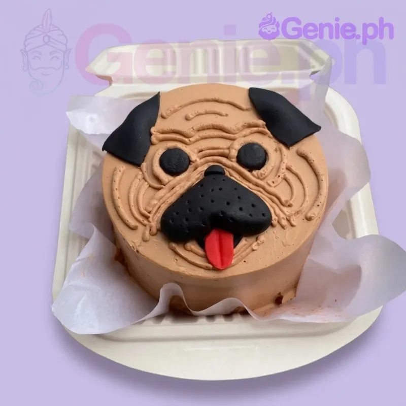 A tan, black, and red Bento cake themed around a Pug Dog, featuring a detailed pug face with icing wrinkles, black ears, and a red tongue. A tan, black, and red Bento cake themed around a Pug Dog, featuring a detailed pug face with icing wrinkles, black ears, and a red tongue.