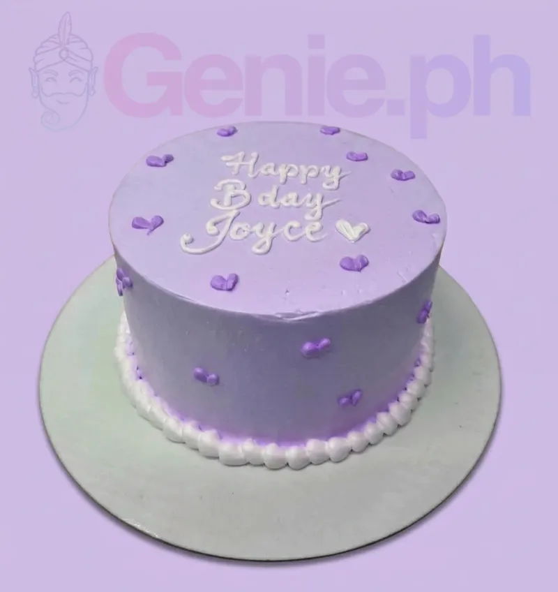 A lavender and white 1-tier minimalist cake with a white piped message, small purple hearts, and a white rosette border. A lavender and white 1-tier minimalist cake with a white piped message, small purple hearts, and a white rosette border.