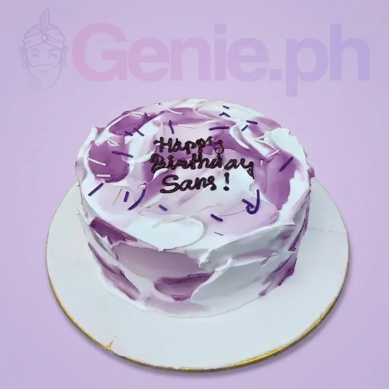 A white and purple 1-tier cake, featuring palette knife icing, purple and white sprinkles, and a 'Happy Birthday Sans!' message. A white and purple 1-tier cake, featuring palette knife icing, purple and white sprinkles, and a 'Happy Birthday Sans!' message.