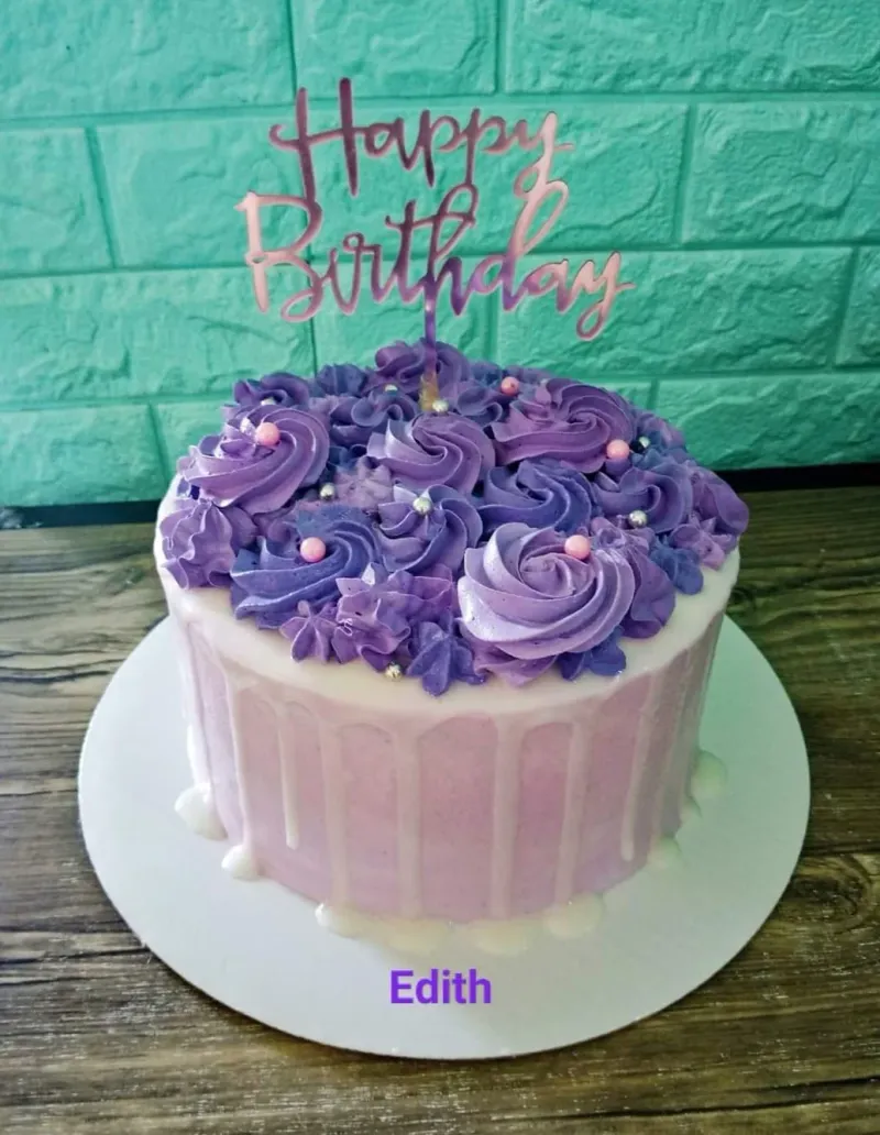 A purple and pink 1-tier birthday cake with purple icing rosettes, silver dragees, and a rose gold Happy Birthday topper. A purple and pink 1-tier birthday cake with purple icing rosettes, silver dragees, and a rose gold Happy Birthday topper.