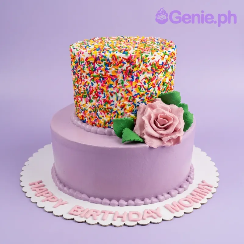 Two-tier purple birthday cake with a sprinkle-covered top tier and a large pink fondant rose accent. Two-tier purple birthday cake with a sprinkle-covered top tier and a large pink fondant rose accent.