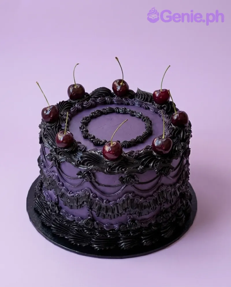 A purple and black 1-tier cake themed around vintage elegance, featuring fresh cherries and black piped icing ruffles.