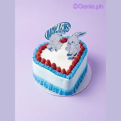 Light blue heart-shaped cake with red strawberry border and cartoon rabbit and speech bubble printout toppers Light blue heart-shaped cake with red strawberry border and cartoon rabbit and speech bubble printout toppers