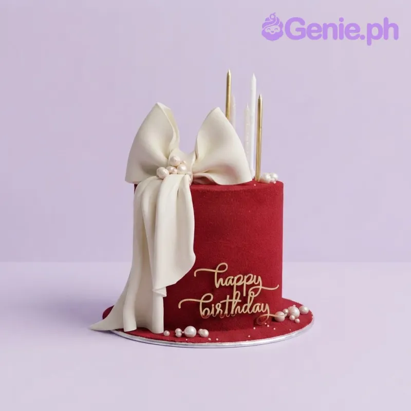 Dark red 1-tier birthday cake with smooth soft icing, a large white fondant bow, and a gold acrylic message Dark red 1-tier birthday cake with smooth soft icing, a large white fondant bow, and a gold acrylic message
