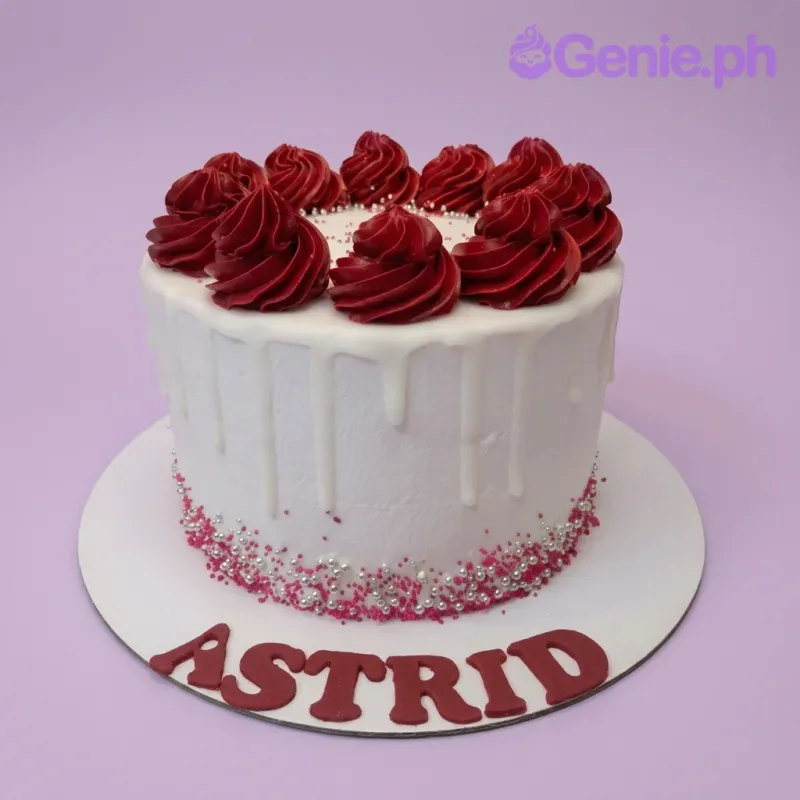 A white and red 1 Tier minimalist cake, featuring deep red rosettes, white chocolate drip, and silver and pink sprinkles. A white and red 1 Tier minimalist cake, featuring deep red rosettes, white chocolate drip, and silver and pink sprinkles.