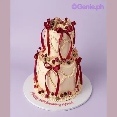 White 2-tier cake with red satin ribbon bows and piped heart decorations White 2-tier cake with red satin ribbon bows and piped heart decorations