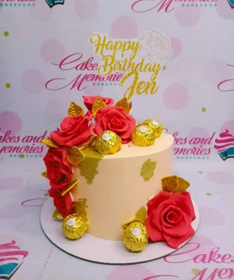 A peach 1-tier Red Rose Birthday cake, featuring large red gumpaste roses, a gold glitter topper, and Ferrero Rocher chocolates. A peach 1-tier Red Rose Birthday cake, featuring large red gumpaste roses, a gold glitter topper, and Ferrero Rocher chocolates.