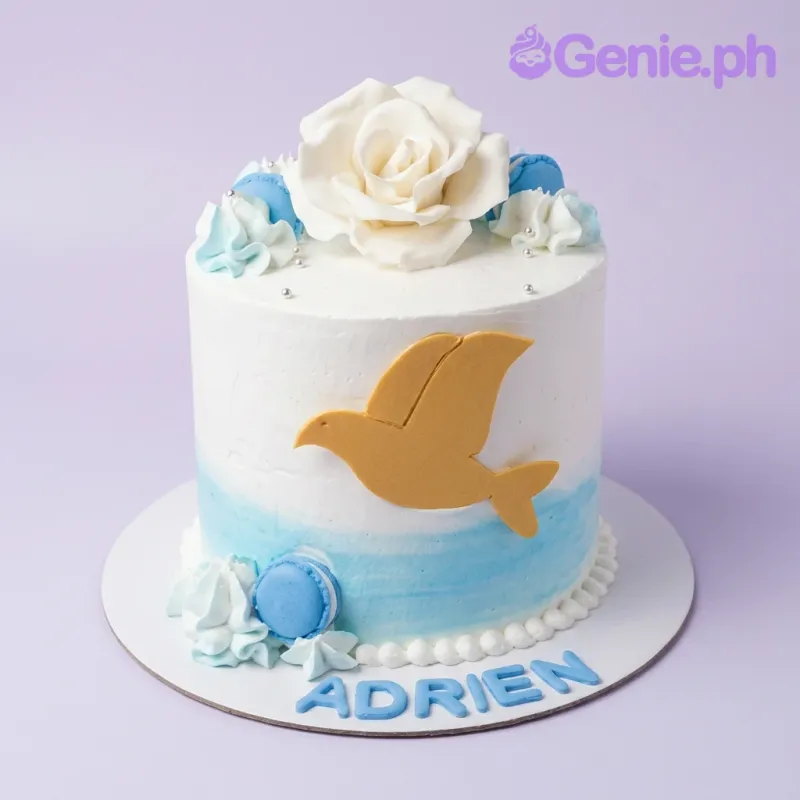 White and light blue ombre cake with a large white gumpaste rose, blue macarons, and a gold dove silhouette. White and light blue ombre cake with a large white gumpaste rose, blue macarons, and a gold dove silhouette.