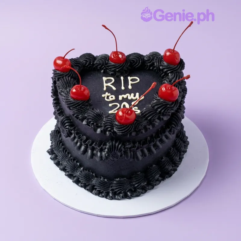 Black heart-shaped cake with red cherries and white RIP to my 20's message Black heart-shaped cake with red cherries and white RIP to my 20's message