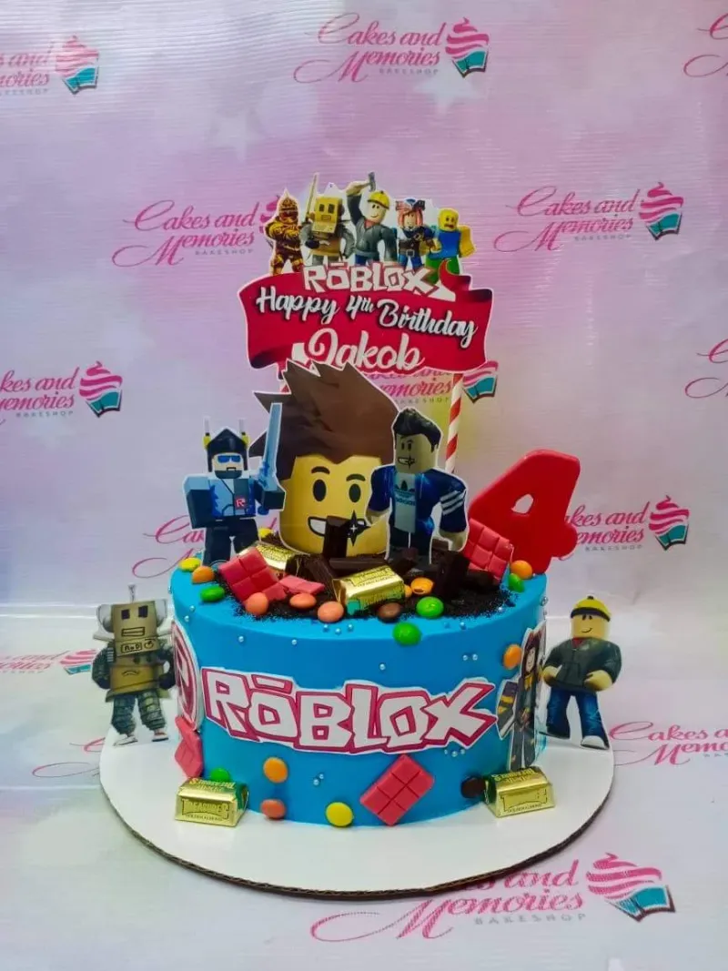 A blue 1 Tier cake themed around Roblox, featuring character printouts, a red number four, chocolate bars, and colorful candy. A blue 1 Tier cake themed around Roblox, featuring character printouts, a red number four, chocolate bars, and colorful candy.