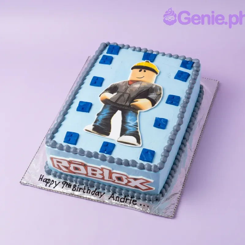 A light blue rectangular Roblox themed cake, featuring a large character printout, Roblox logo, dark blue square blocks, and dark gray icing rosettes. A light blue rectangular Roblox themed cake, featuring a large character printout, Roblox logo, dark blue square blocks, and dark gray icing rosettes.