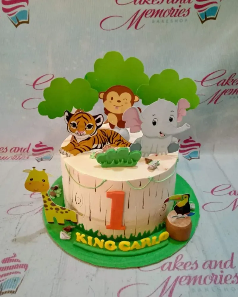 A multi-colored 1-tier Safari Animal cake, with animal printouts, green trees, and an orange number one. A multi-colored 1-tier Safari Animal cake, with animal printouts, green trees, and an orange number one.