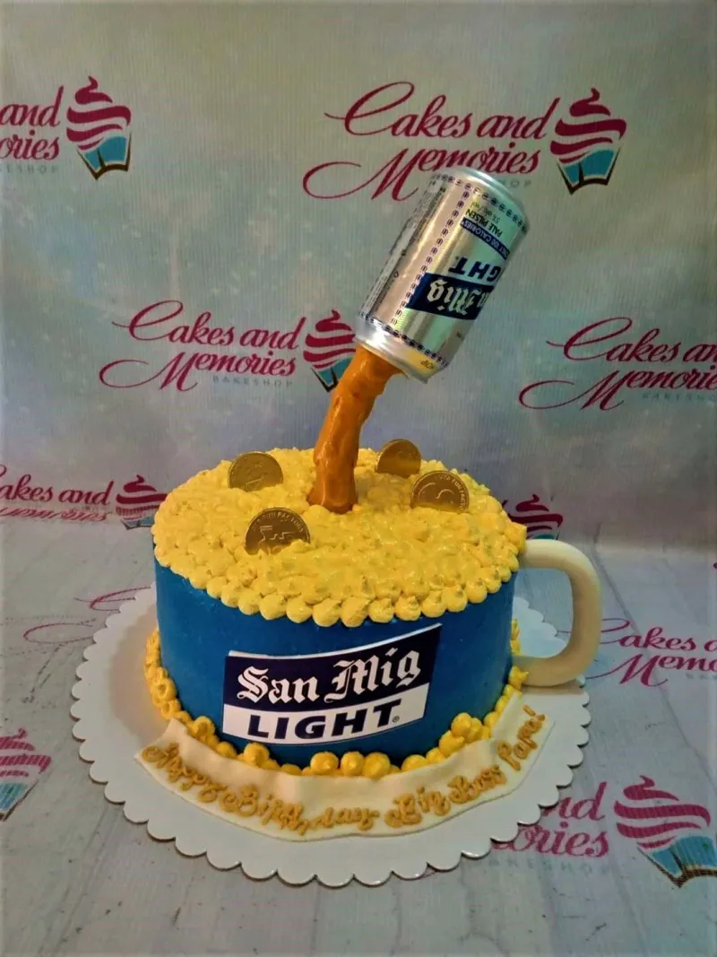 A blue 1-tier San Mig Light Beer cake with yellow icing foam, gold coins, and a pouring beer can topper. A blue 1-tier San Mig Light Beer cake with yellow icing foam, gold coins, and a pouring beer can topper.