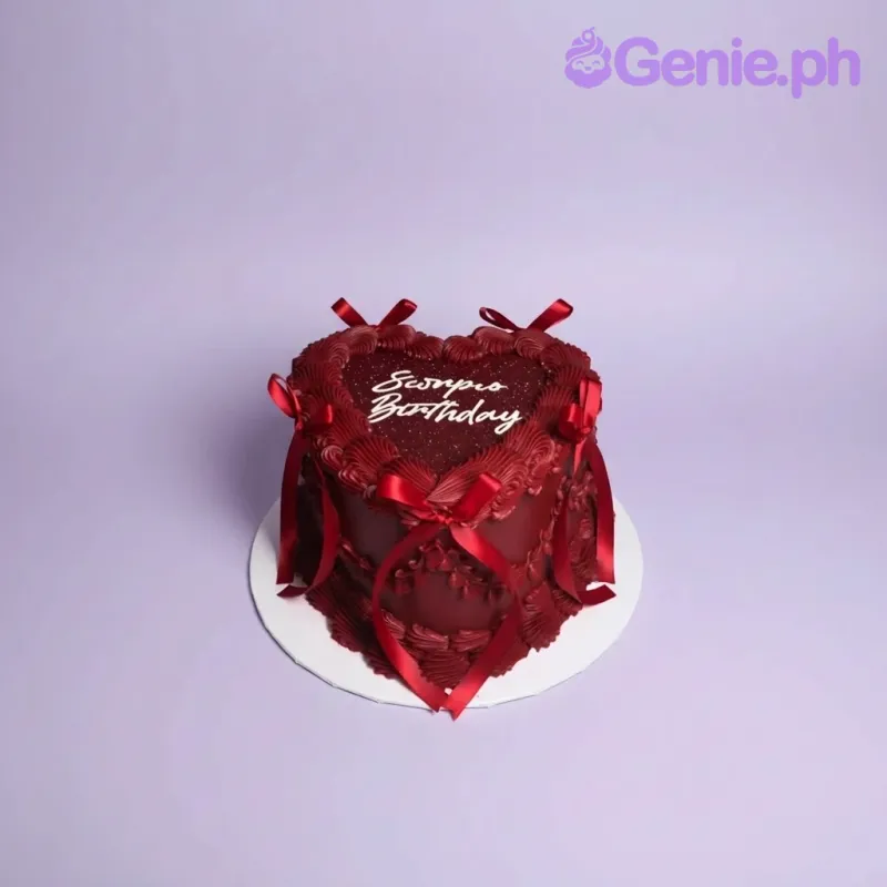 A dark red heart-shaped Scorpio Birthday cake, with 'Scorpio Birthday' text, ruffles, and red satin bows. A dark red heart-shaped Scorpio Birthday cake, with 'Scorpio Birthday' text, ruffles, and red satin bows.