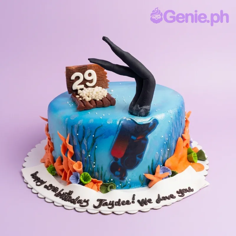 A blue 1 Tier Fondant Scuba Diving cake, featuring a 3D diver, coral, and a birthday message. A blue 1 Tier Fondant Scuba Diving cake, featuring a 3D diver, coral, and a birthday message.