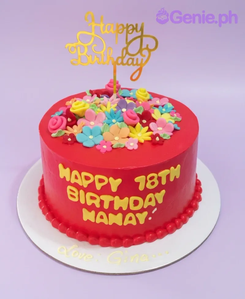 A red and colorful 1-tier Senior Birthday cake featuring a gold 'Happy Birthday' topper and vibrant fondant flowers. A red and colorful 1-tier Senior Birthday cake featuring a gold 'Happy Birthday' topper and vibrant fondant flowers.