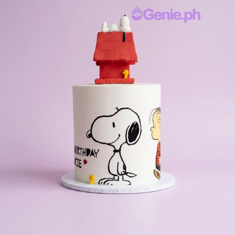 White 1-tier birthday cake with Snoopy doghouse topper and Snoopy and Linus character prints White 1-tier birthday cake with Snoopy doghouse topper and Snoopy and Linus character prints