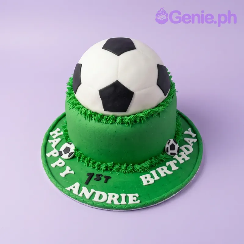A green, white, and black 1 Tier Fondant cake themed around Soccer Ball, featuring a large 3D soccer ball and grass texture. A green, white, and black 1 Tier Fondant cake themed around Soccer Ball, featuring a large 3D soccer ball and grass texture.