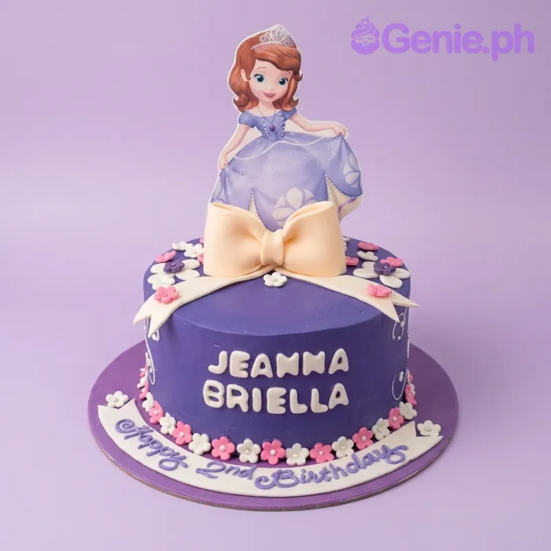 A purple Sofia the First themed 1 Tier cake featuring a large character printout, a white fondant bow, and pink and white icing flowers. A purple Sofia the First themed 1 Tier cake featuring a large character printout, a white fondant bow, and pink and white icing flowers.