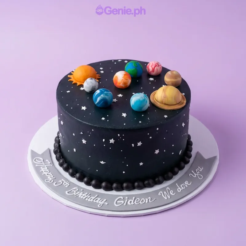 A black and colorful 1-tier cake themed around the Solar System, featuring fondant Saturn, sun, planets, and white icing stars. A black and colorful 1-tier cake themed around the Solar System, featuring fondant Saturn, sun, planets, and white icing stars.