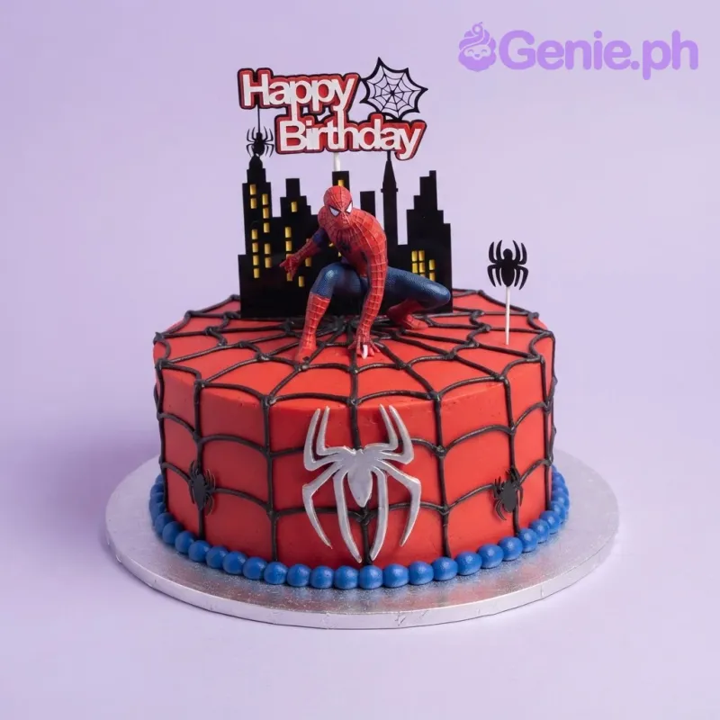 Red 1-tier soft icing birthday cake with black spiderweb piping, Spider-Man figure, cityscape topper, and blue base border Red 1-tier soft icing birthday cake with black spiderweb piping, Spider-Man figure, cityscape topper, and blue base border