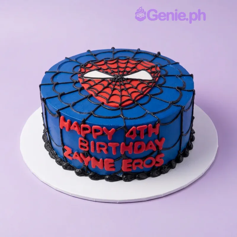 A blue, black, red, and white 1 Tier Spiderman cake, featuring a Spiderman mask printout and black piped spider webs. A blue, black, red, and white 1 Tier Spiderman cake, featuring a Spiderman mask printout and black piped spider webs.