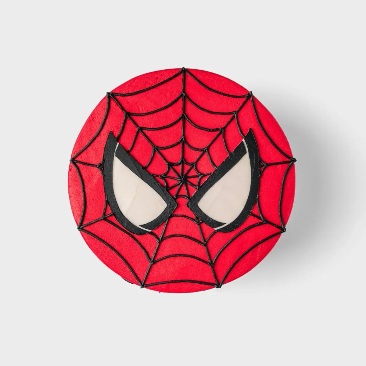 Bright red 1-tier soft icing cake with black piped spider web lines and large white and black Spiderman eyes on top Bright red 1-tier soft icing cake with black piped spider web lines and large white and black Spiderman eyes on top