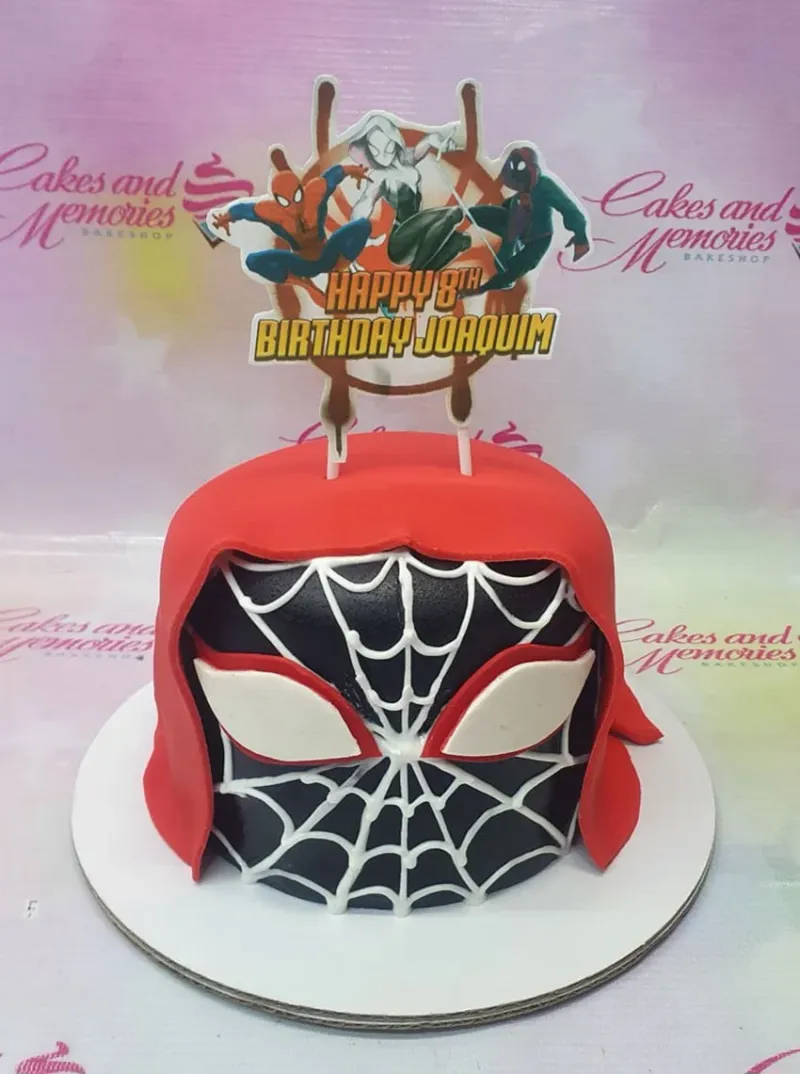 A black, red, and white 1 Tier Fondant Spiderman cake with a printout, white web designs, and a red fondant hood. A black, red, and white 1 Tier Fondant Spiderman cake with a printout, white web designs, and a red fondant hood.