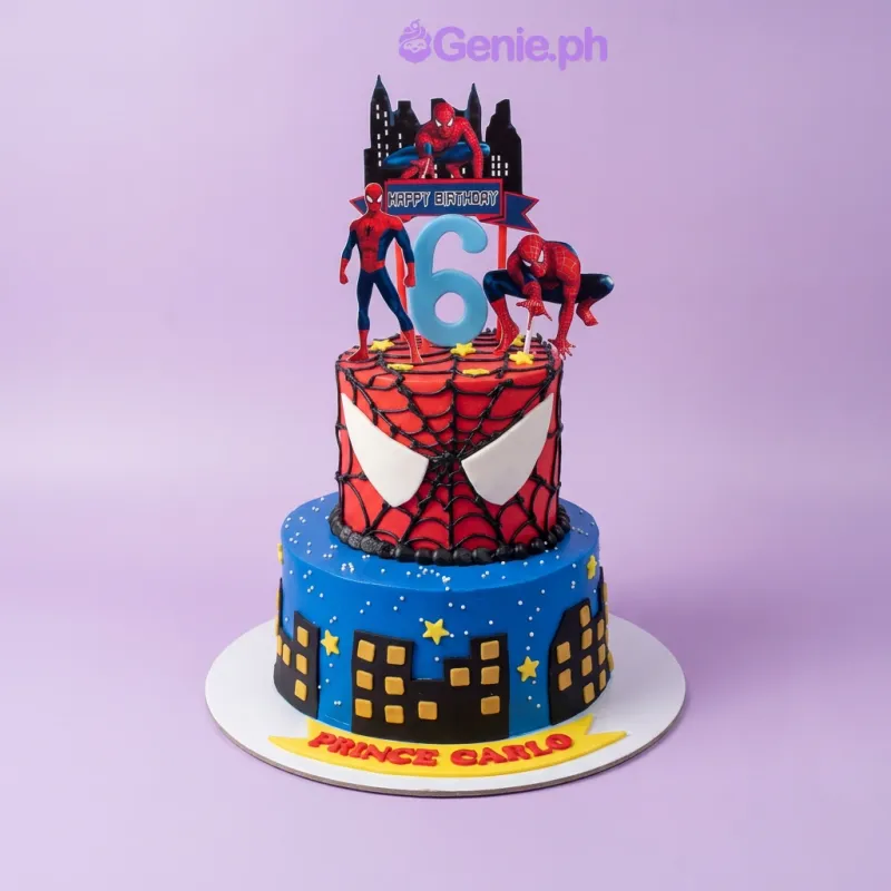 A red and blue two-tier fondant Spiderman cake, featuring Spiderman character cutouts, a blue number six, city skyline, and web piping. A red and blue two-tier fondant Spiderman cake, featuring Spiderman character cutouts, a blue number six, city skyline, and web piping.