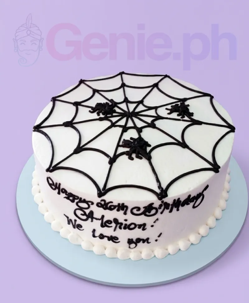 A white round 1 Tier cake themed around Spiderman, featuring a black piped spiderweb design and black spider silhouettes. A white round 1 Tier cake themed around Spiderman, featuring a black piped spiderweb design and black spider silhouettes.
