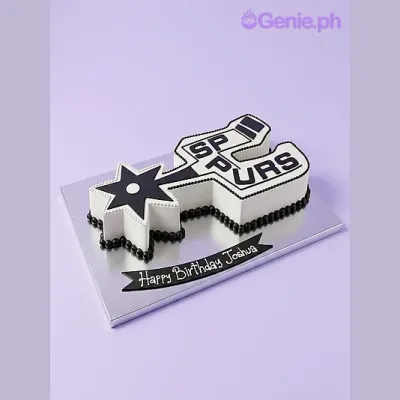 White shaped cake with black San Antonio Spurs logo design and Happy Birthday Joshua banner on silver board White shaped cake with black San Antonio Spurs logo design and Happy Birthday Joshua banner on silver board