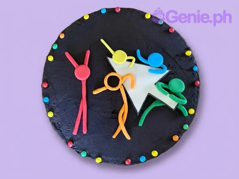 A black 1-tier cake, Stick Figure Animation themed, featuring colorful stick figures, a white cursor arrow, and icing dots. A black 1-tier cake, Stick Figure Animation themed, featuring colorful stick figures, a white cursor arrow, and icing dots.