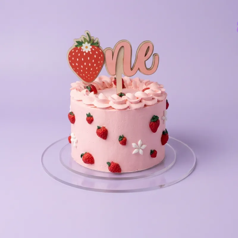 Pink 1-tier birthday cake with strawberry and one text topper and fondant strawberry accents Pink 1-tier birthday cake with strawberry and one text topper and fondant strawberry accents
