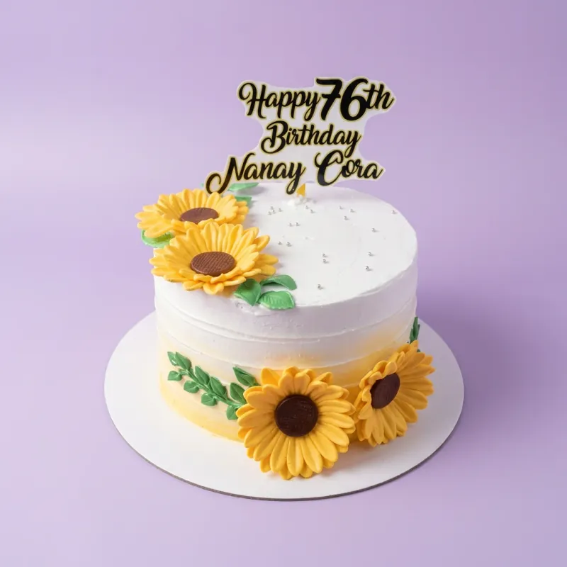 A white and yellow 1-tier cake themed around Sunflowers, featuring a 'Happy 76th Birthday Nanay Cora' topper, edible sunflowers, and silver dragees. A white and yellow 1-tier cake themed around Sunflowers, featuring a 'Happy 76th Birthday Nanay Cora' topper, edible sunflowers, and silver dragees.